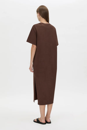 Juno Knot Tee Dress by Camilla and Marc — a chocolate cotton maxi with an asymmetric cut-out and draped knot detail for modern everyday wear.
