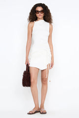 Lana Asym Mini Dress by Bec and Bridge — an ivory asymmetric mini with a tucked waist and beaded ties, perfect for chic daytime styling.