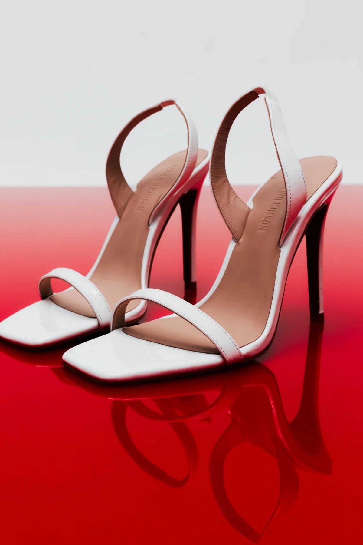 Lana Wilkinson Cassidy Sandal in white patent leather with slim stiletto heel and squared-off toe, perfect for party or summer wear.