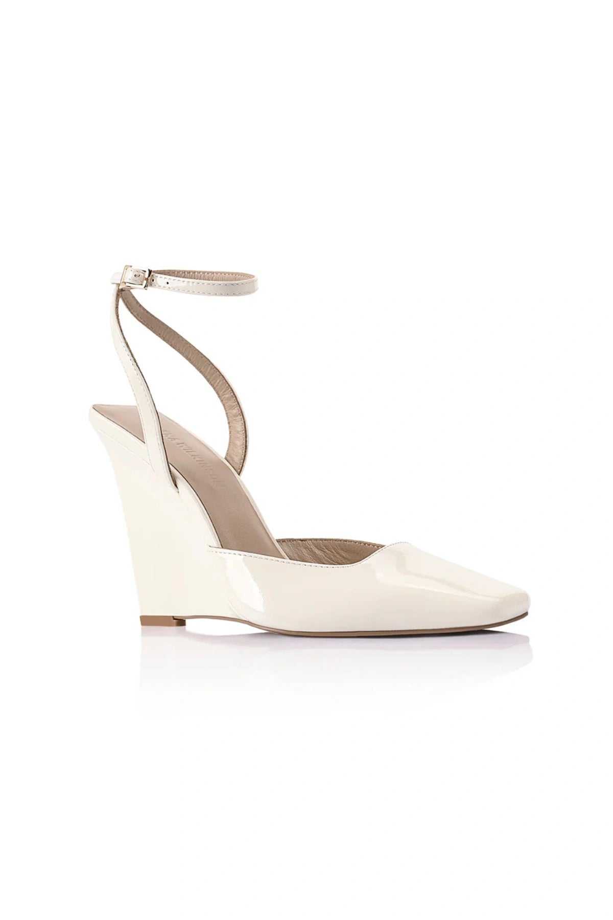Lana Wilkinson Mona Wedge in glossy ivory patent leather with pointed toe, ankle strap, and sculptural wedge heel.