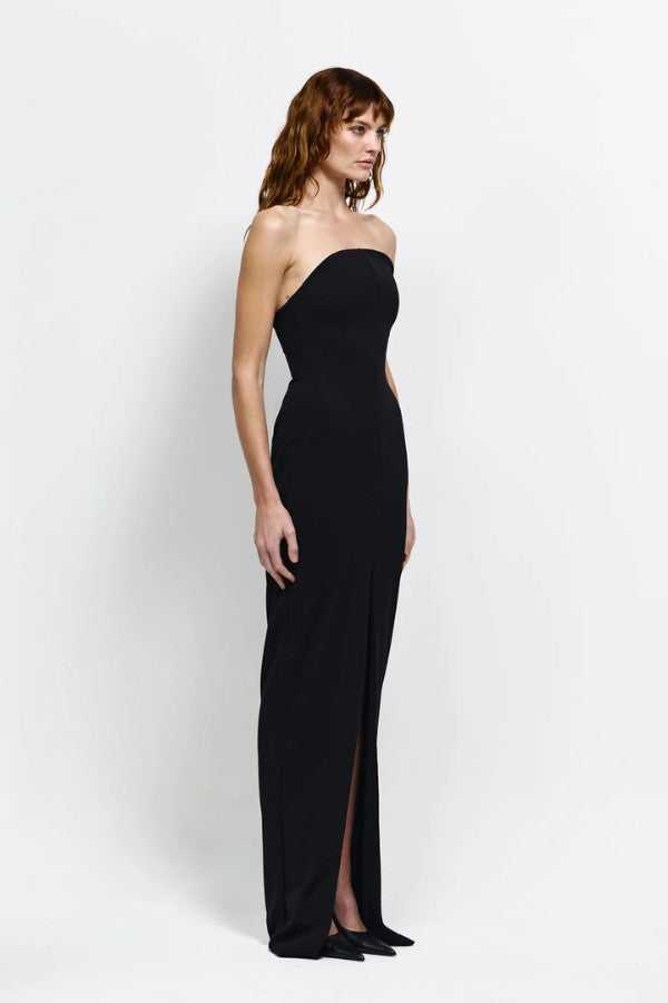 Lani Gown in Black by Effie Kats, a strapless floor-length stretch gown with curved neckline, cinched waist, and daring front split for statement elegance.