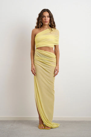 Lara Dress Yellow by DŽO – a one-shoulder gown with ruched wrap and slit. Perfect for bold evening styling.