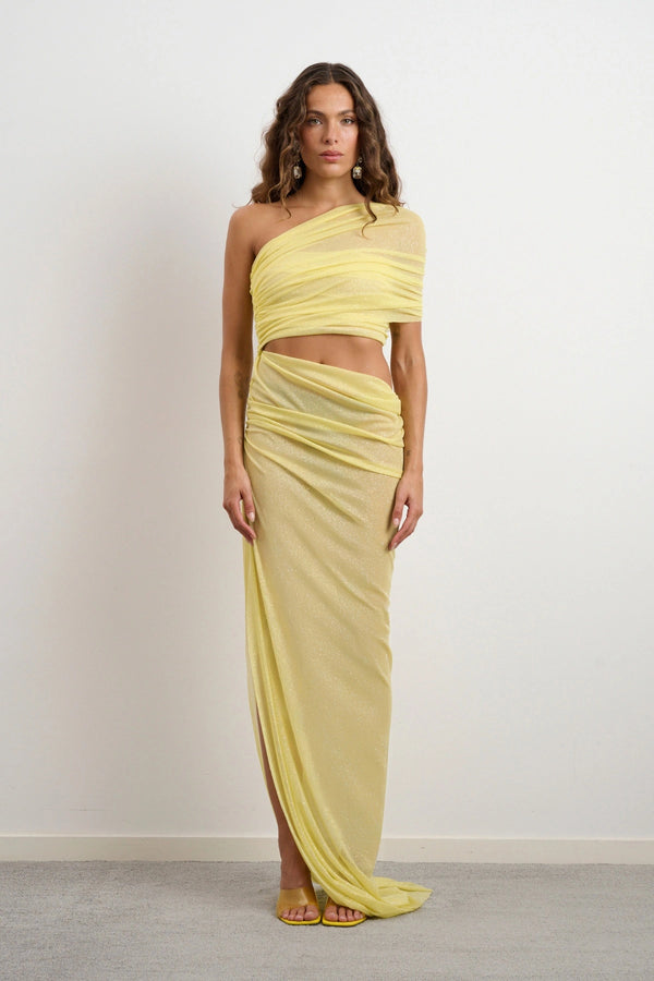 Lara Dress Yellow by DŽO – a one-shoulder gown with ruched wrap and slit. Perfect for bold evening styling.