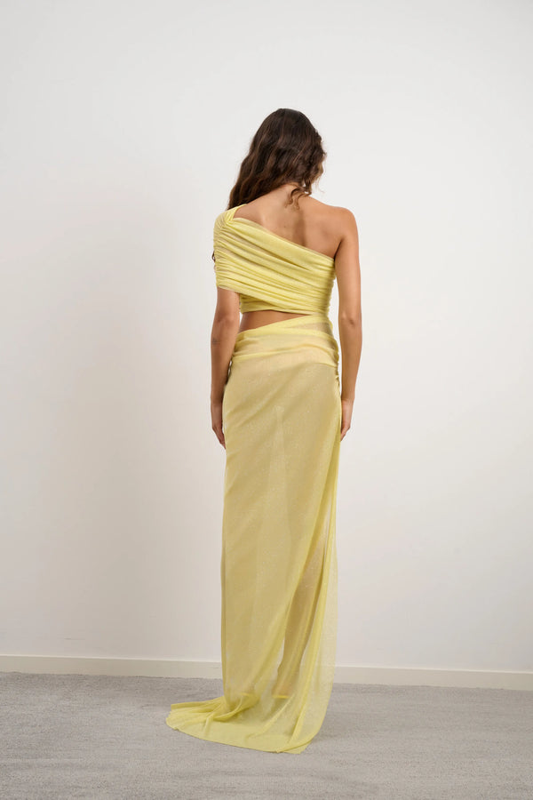 Lara Dress Yellow by DŽO – a one-shoulder gown with ruched wrap and slit. Perfect for bold evening styling.