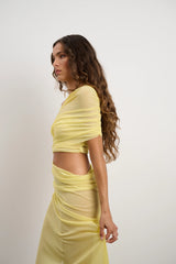 Lara Dress Yellow by DŽO – a one-shoulder gown with ruched wrap and slit. Perfect for bold evening styling.