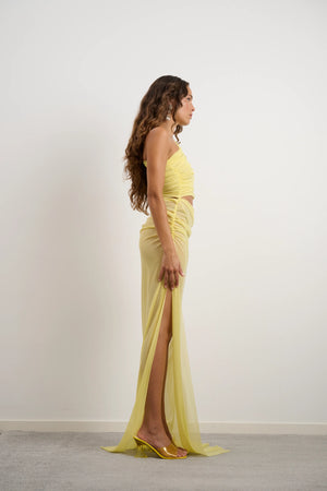 Lara Dress Yellow by DŽO – a one-shoulder gown with ruched wrap and slit. Perfect for bold evening styling.
