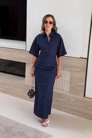 Lefka Midi Dress Navy by Sneaky Link – a linen midi with ruched waist and puff sleeves. Perfect for effortless event styling.