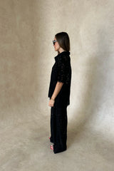 Lucy V-Neck Shirt in Black by Sneaky Link, crafted in sheer floral lace with a button front and relaxed fit. Ideal for matching sets.
