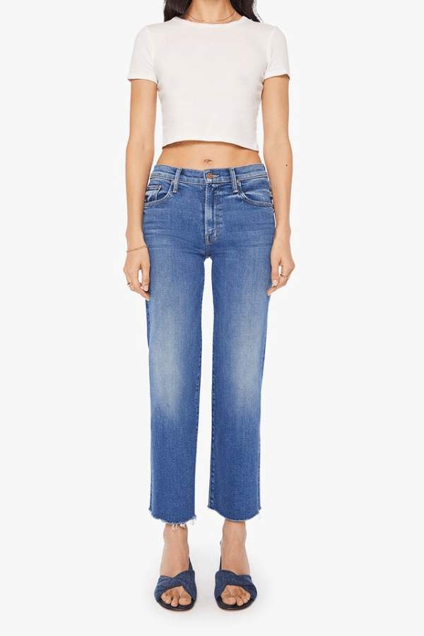 The Mid Rise Rambler Zip Ankle Fray Dugout Doobies by MOTHER, stretch denim jeans with vintage fade and frayed hem. Perfect for off-duty days.