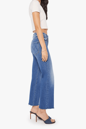 The Mid Rise Rambler Zip Ankle Fray Dugout Doobies by MOTHER, stretch denim jeans with vintage fade and frayed hem. Perfect for off-duty days.