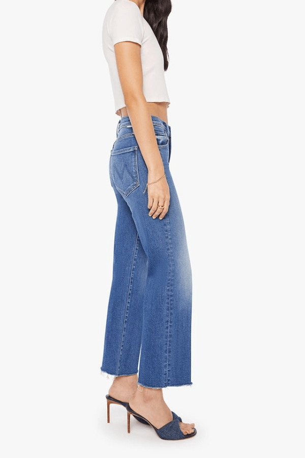 The Mid Rise Rambler Zip Ankle Fray Dugout Doobies by MOTHER, stretch denim jeans with vintage fade and frayed hem. Perfect for off-duty days.