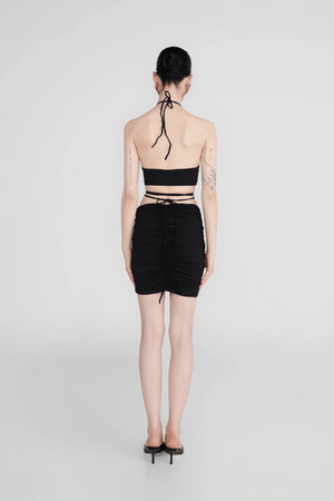 Margua Skirt Black by Maygel Coronel, ruched mini skirt with 3D floral detail. Perfect for beach styling or standout looks.