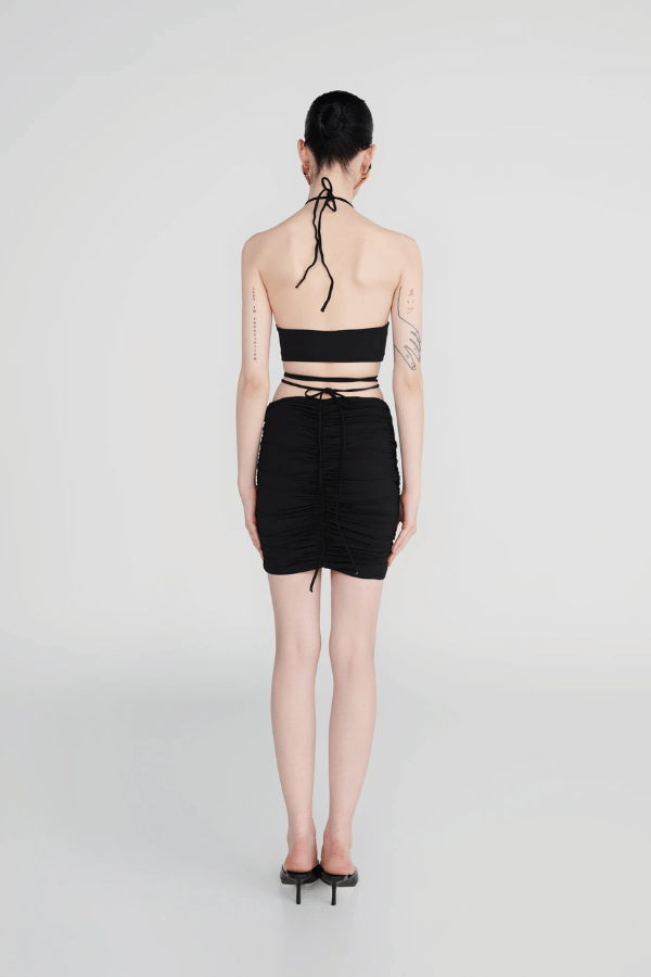 Margua Skirt Black by Maygel Coronel, ruched mini skirt with 3D floral detail. Perfect for beach styling or standout looks.