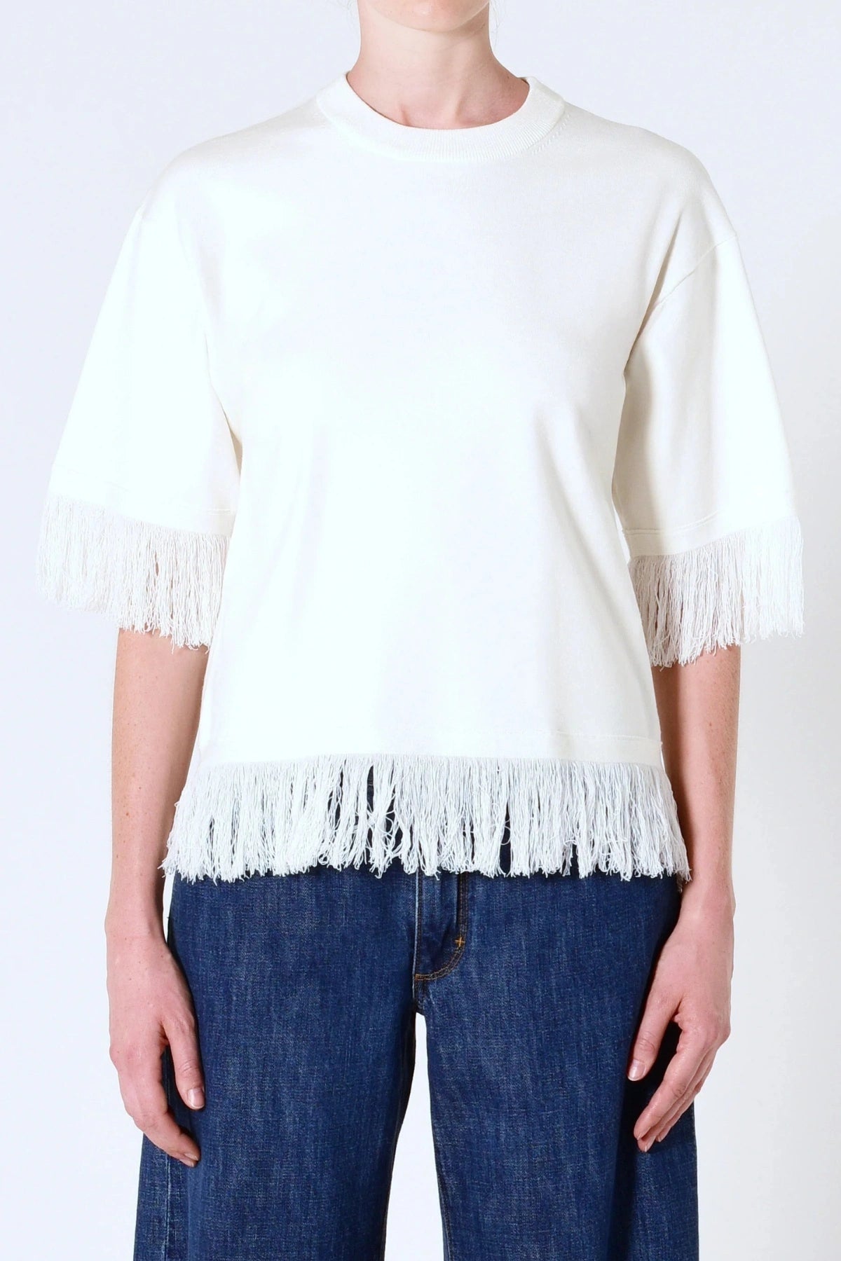 Marrakech Fringe Knit in White by Neuw Denim, a sleeveless relaxed knit with fringe hem. Perfect for layering with denim or linen.
