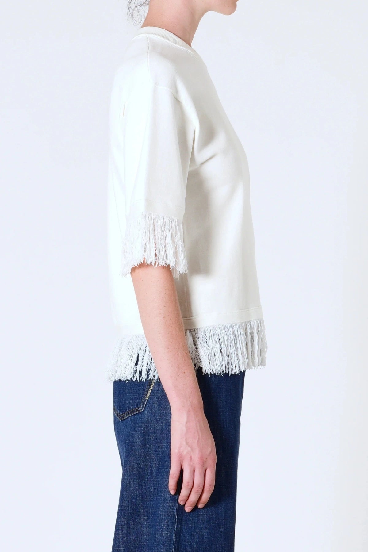 Marrakech Fringe Knit in White by Neuw Denim, a sleeveless relaxed knit with fringe hem. Perfect for layering with denim or linen.
