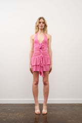 Monica Dress in Fucsia by DŽO, a ruched power mesh mini with plunging halter neckline, floral appliqué, and tiered layers.