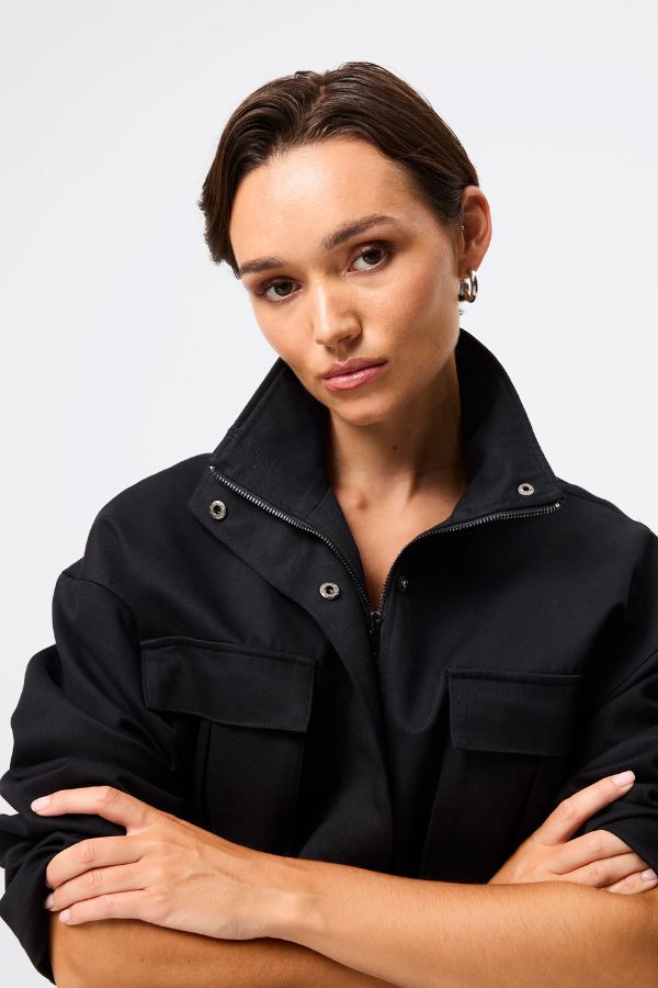 Mossman My Muse Anorak in Black, a modern utility jacket featuring oversized flap pockets, adjustable drawstring waist, and a concealed zip front for an elevated off-duty look. 4 