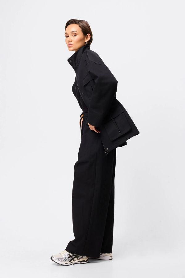 Mossman My Muse Anorak in Black, a modern utility jacket featuring oversized flap pockets, adjustable drawstring waist, and a concealed zip front for an elevated off-duty look. 4 