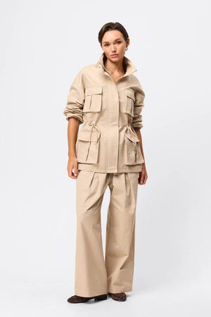 Mossman My Muse Anorak in Natural, a timeless utility jacket with oversized flap pockets, adjustable drawstring waist, and a concealed zip front for effortless layering.