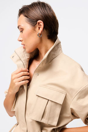 Mossman My Muse Anorak in Natural, a timeless utility jacket with oversized flap pockets, adjustable drawstring waist, and a concealed zip front for effortless layering.