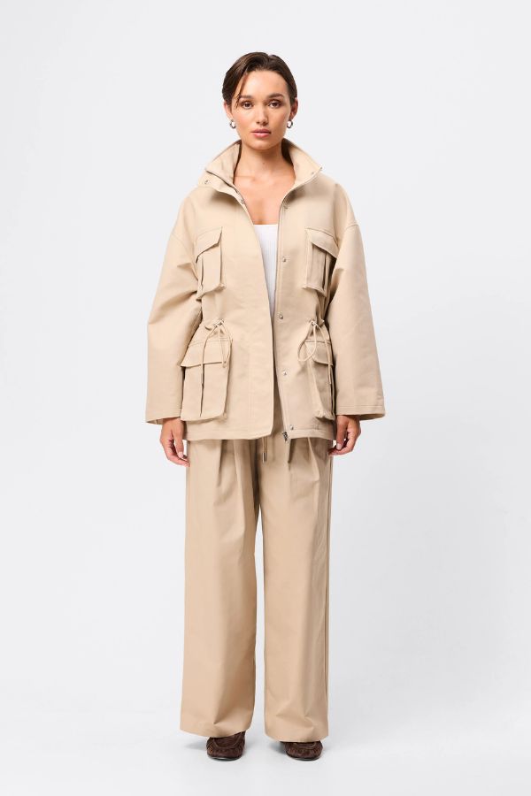 Mossman My Muse Anorak in Natural, a timeless utility jacket with oversized flap pockets, adjustable drawstring waist, and a concealed zip front for effortless layering.