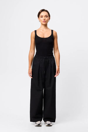 Mossman Tied Down Pant in Black, a wide-leg cotton pant featuring an elasticated waistband with adjustable toggle and functional pockets for chic utility style.