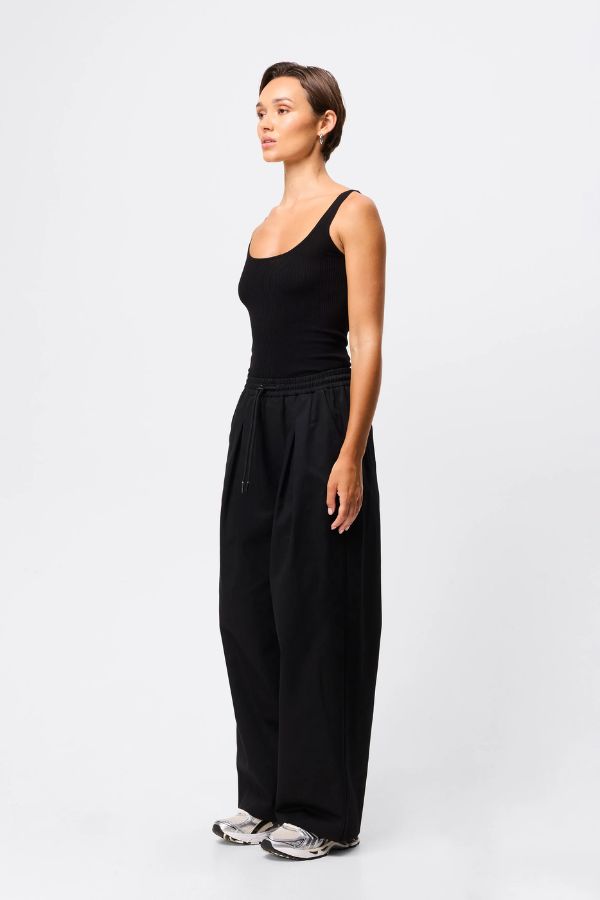 Mossman Tied Down Pant in Black, a wide-leg cotton pant featuring an elasticated waistband with adjustable toggle and functional pockets for chic utility style.