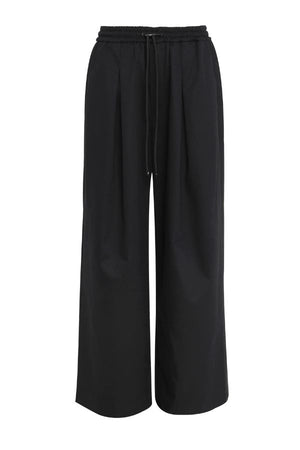 Mossman Tied Down Pant in Black, a wide-leg cotton pant featuring an elasticated waistband with adjustable toggle and functional pockets for chic utility style.