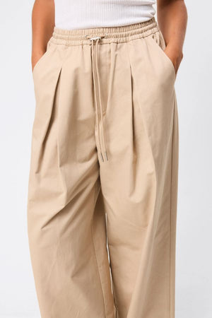 Mossman Tied Down Pant in Natural, a relaxed wide-leg cotton pant featuring an elasticated waistband with adjustable toggle and functional pockets for versatile everyday style. 2