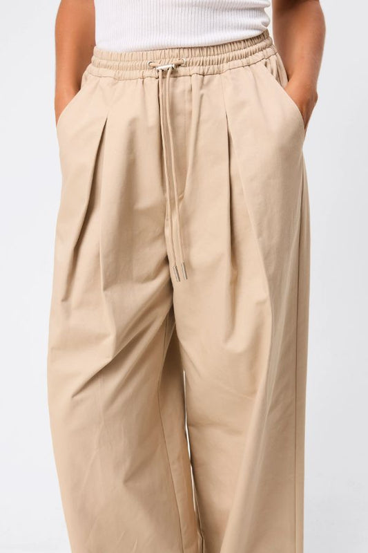 Mossman Tied Down Pant in Natural, a relaxed wide-leg cotton pant featuring an elasticated waistband with adjustable toggle and functional pockets for versatile everyday style. 2