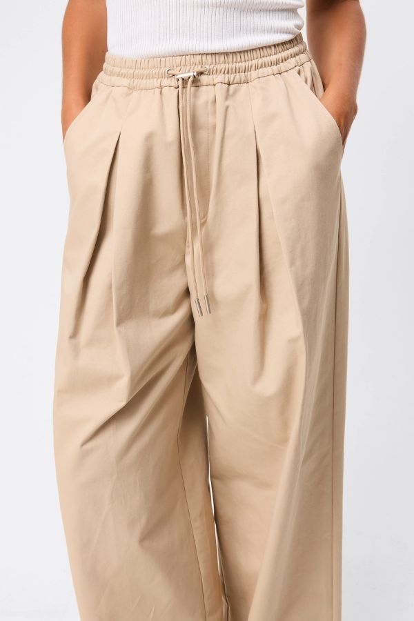 Mossman Tied Down Pant in Natural, a relaxed wide-leg cotton pant featuring an elasticated waistband with adjustable toggle and functional pockets for versatile everyday style. 2