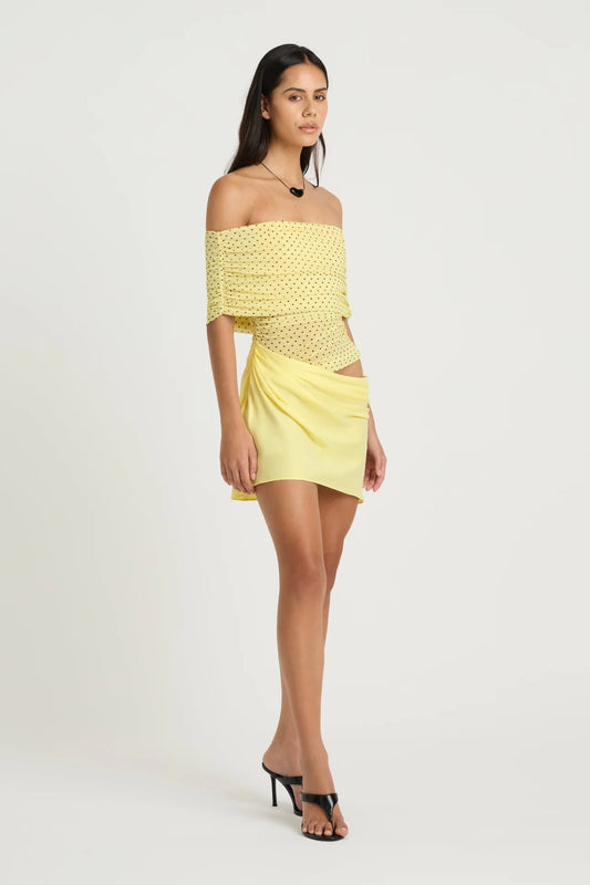 Nico Off Shoulder Mini Dress Yellow Spot by Benni, a sheer mesh mini with draped cupro skirt and cowl waist. Perfect for statement dressing.