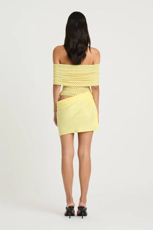 Nico Off Shoulder Mini Dress Yellow Spot by Benni, a sheer mesh mini with draped cupro skirt and cowl waist. Perfect for statement dressing.