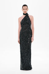 Nicolette Crochet Sequin Dress by Misha, a halter column gown in shimmering black sequins with draped sash detail for modern evening elegance.