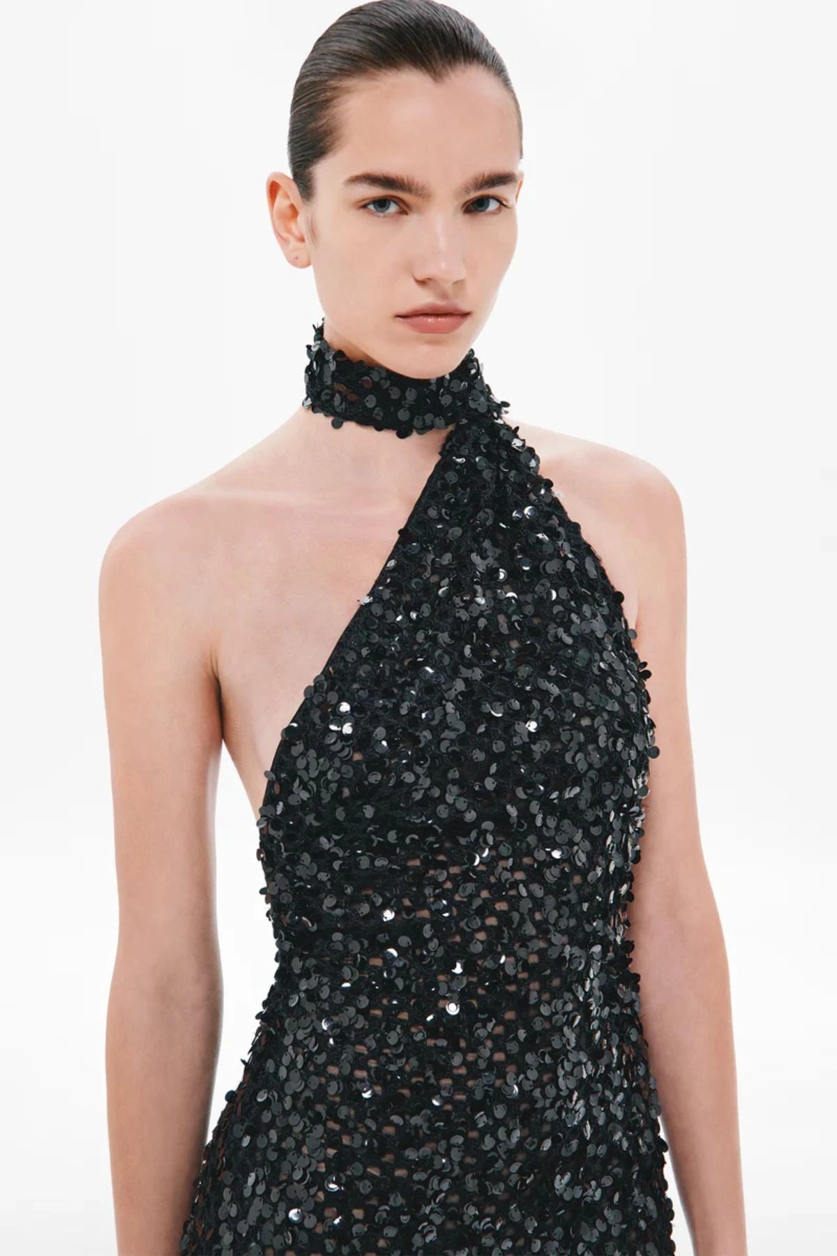 Nicolette Crochet Sequin Dress by Misha, a halter column gown in shimmering black sequins with draped sash detail for modern evening elegance.