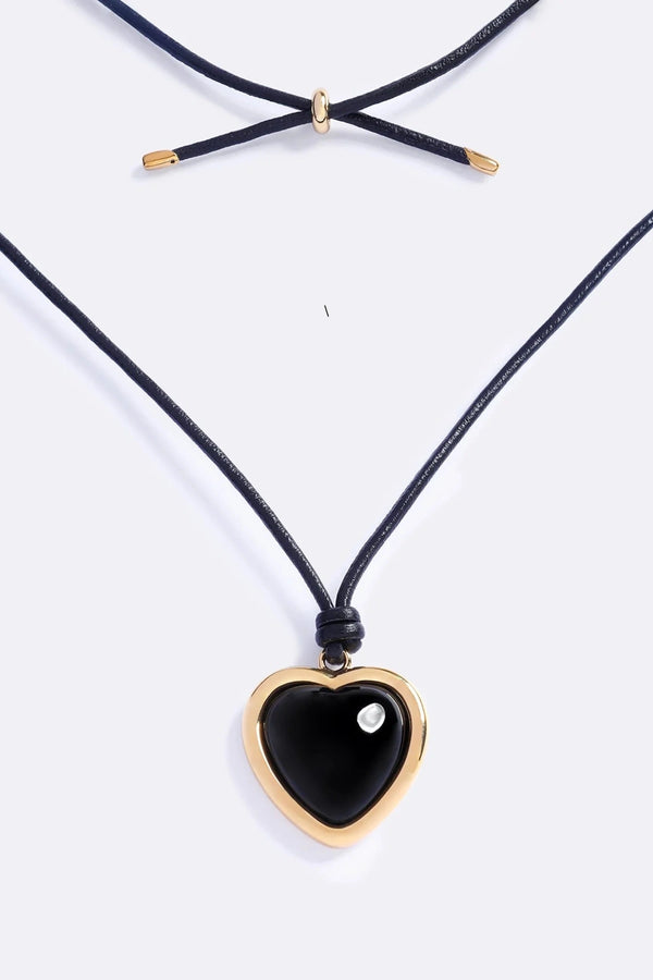 Nightgasm Necklace in Black Glow by Emma Pills, featuring a bold enamel heart pendant on adjustable leather rope. Ideal for standout layering.
