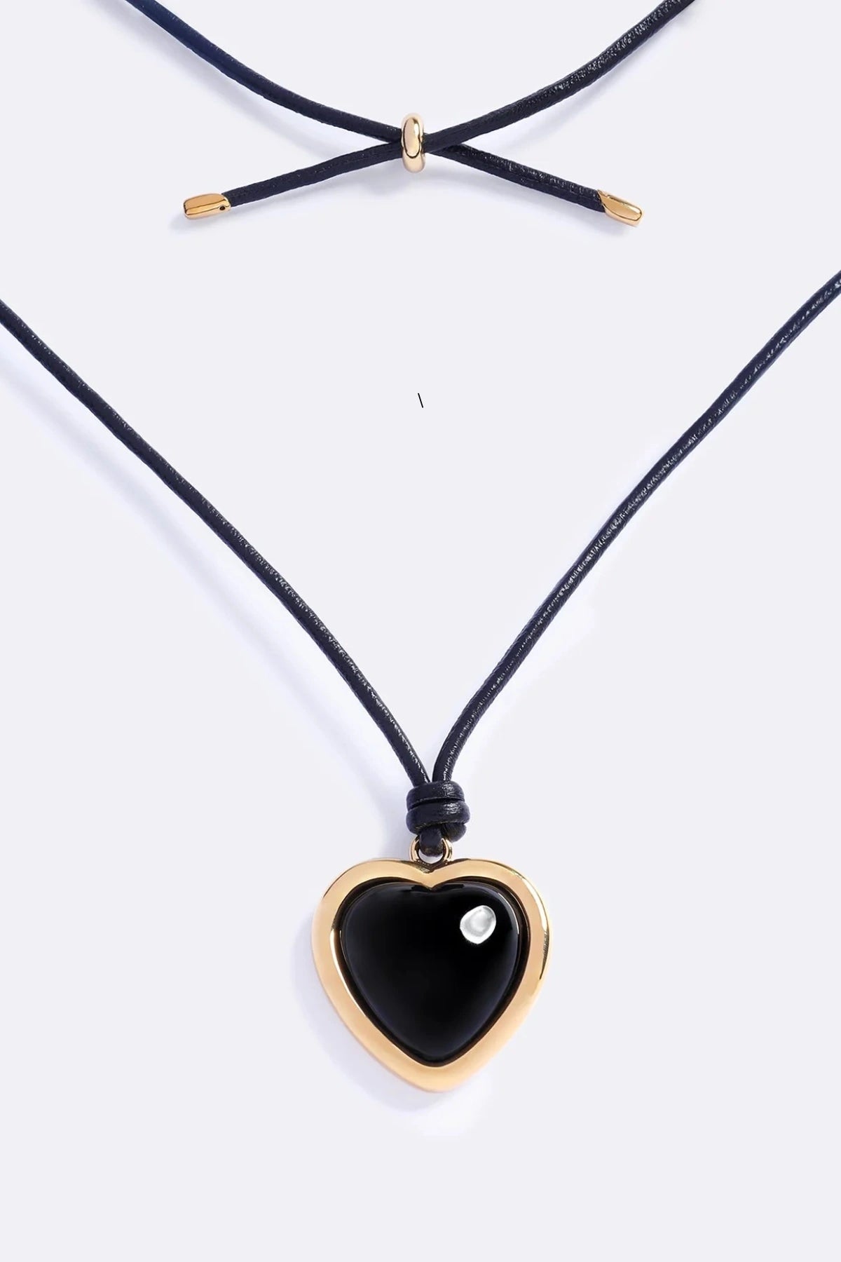Nightgasm Necklace in Black Glow by Emma Pills, featuring a bold enamel heart pendant on adjustable leather rope. Ideal for standout layering.
