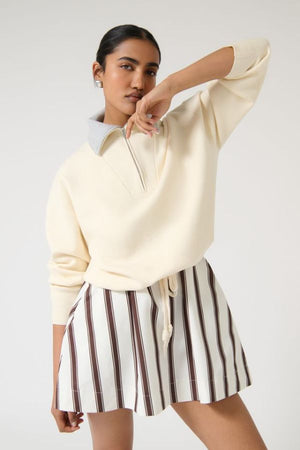 Onte Nerea Sweater in Ivory/Grey, soufflé knit with two-tone collar, half zip, silver hardware, and drawstring waist for versatility.