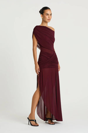 Otto Maxi Dress in Plum by Benni, a one-shoulder stretch mesh maxi with draped detailing, twisted skirt, and front split.