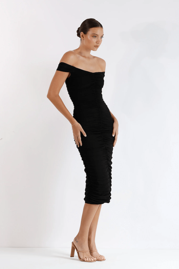New Horizon Tapered Midi Black by Pasduchas – A trendy off-shoulder midi with ruched stretch mesh, sheer straps, and a flattering fitted silhouette. Perfect for elegant evenings and stylish occasions.