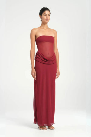 Petra Maxi Dress Wine by Benni, a strapless bandeau dress with a panelled waist, sheer mesh torso, and signature cowl drape for modern elegance. Perfect for formal events