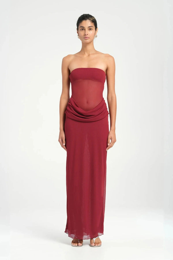 Petra Maxi Dress Wine by Benni, a strapless bandeau dress with a panelled waist, sheer mesh torso, and signature cowl drape for modern elegance. Perfect for formal events