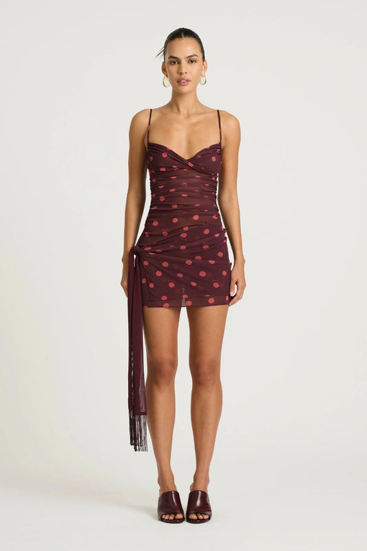 Piper Twist Dress Plum Spot by Benni, a twisted cami mini with draped overlay and tassel waist tie for elevated day-to-night dressing.
