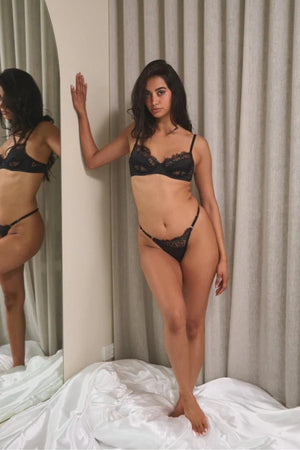 Kat the Label Rae Thong Black, vintage-inspired satin with asymmetrical lace, eyelash trim, mesh back, and adjustable sides for a perfect fit.