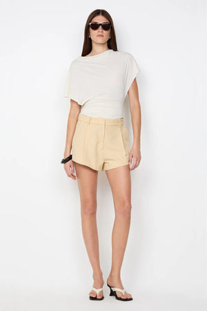 Renzo Short by Bec and Bridge — a tailored sandstone trouser-style short with front tucks and welt pockets, perfect for versatile everyday styling.