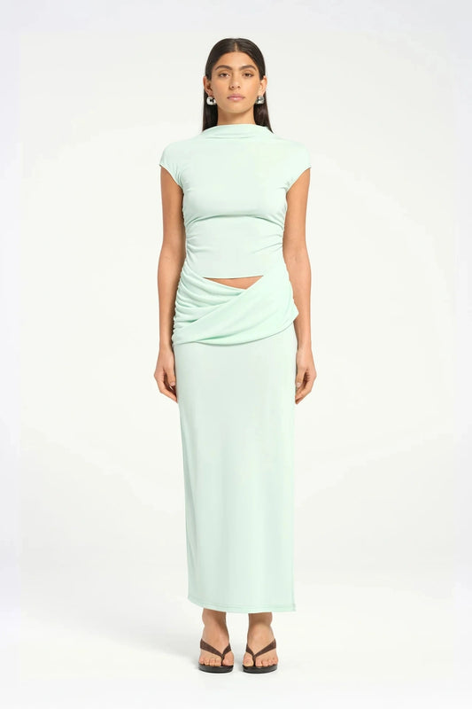 Royce Maxi Dress Aqua by Bec + Bridge, a sleek silhouette with a twisted waist, cowl detail, and side split, perfect for modern evening dressing.