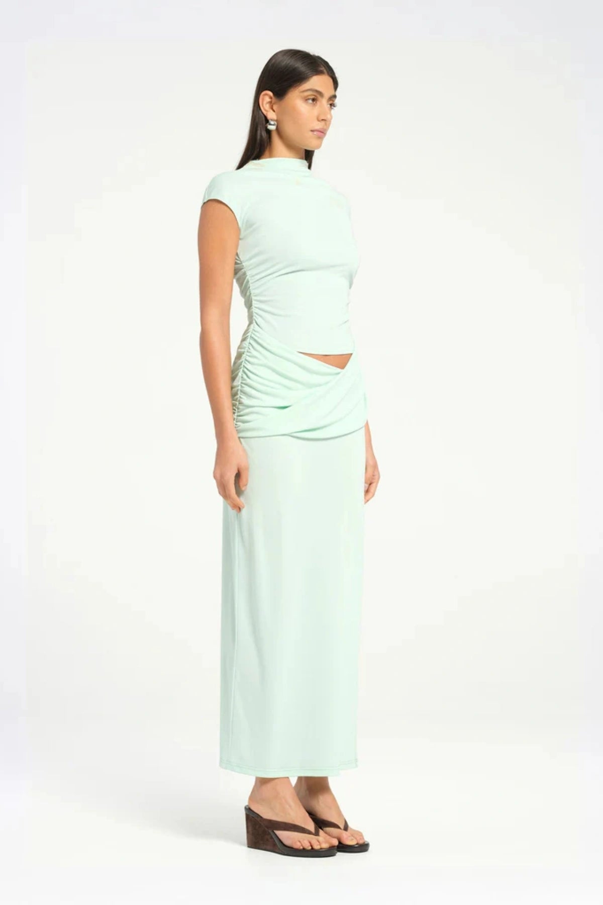 Royce Maxi Dress Aqua by Bec + Bridge, a sleek silhouette with a twisted waist, cowl detail, and side split, perfect for modern evening dressing.