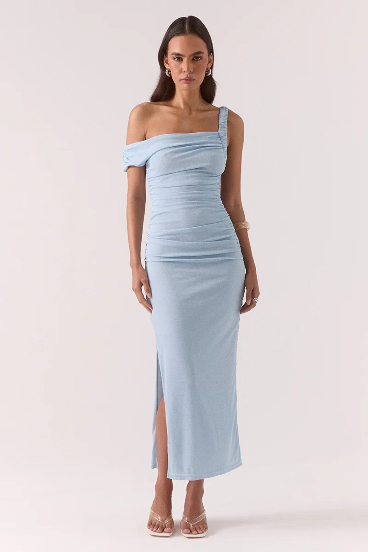 Rua Asym Dress Sky by Sovere — a blue off-shoulder mesh maxi with gathered details and a side split, perfect for modern event styling.

