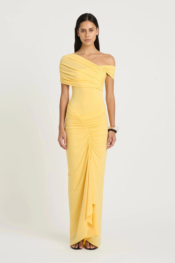 Rumi Maxi Dress by Benni — an asymmetric stretch jersey dress with a gathered skirt and cascading split, offering sheer or solid styling options.