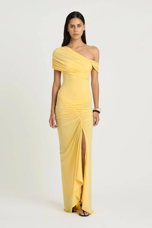 Rumi Maxi Dress by Benni — an asymmetric stretch jersey dress with a gathered skirt and cascading split, offering sheer or solid styling options.